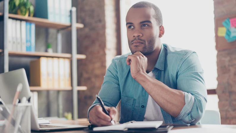 Focused professional planning business development strategies at a desk, symbolizing innovation and strategic thinking.