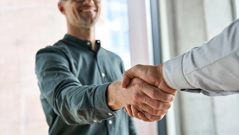 Two happy diverse professional business men executive leaders shaking hands at office meeting.