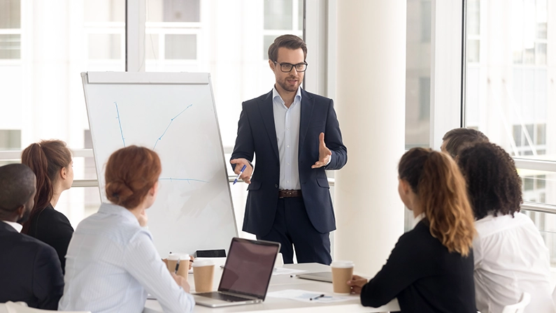 Professional leading a business development coaching session, presenting growth strategies to a team in a modern office setting.