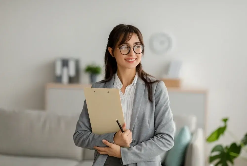 Smiling business professional holding a clipboard, representing expertise in RFP response development for successful proposals.