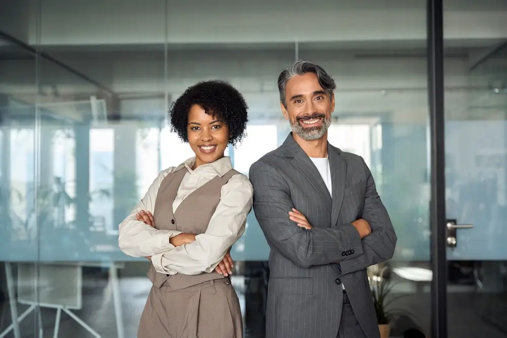 Confident business professionals standing in a modern office, representing innovation and funding opportunities through SBIR Grants.