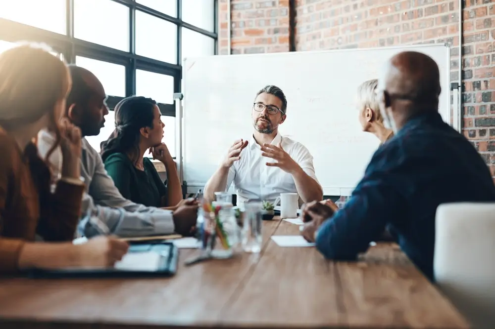 Leader presenting ideas to a diverse team in a meeting, brainstorming winning market strategies for competitive success.