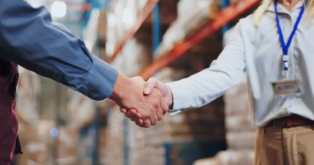 Handshake, agreement and teamwork for people in warehouse, meeting and deal for supply chain.
