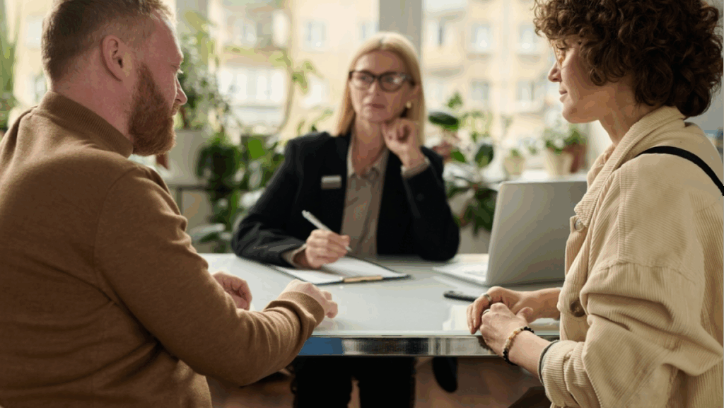 Two people discuss strategies with an advisor, working through bureaucracy in a collaborative environment.