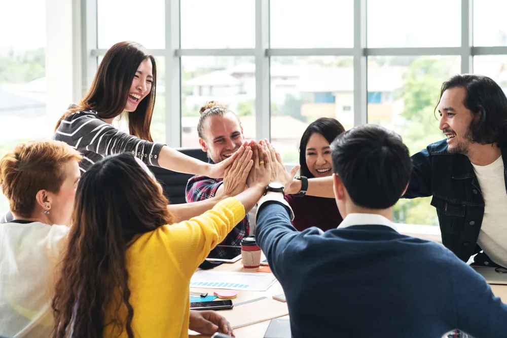 A team celebrates collaboration, with labor analytics guiding their productivity and team-building efforts.