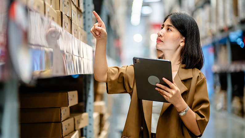 Women warehouse worker using digital tablets to check the stock inventory on shelves in large warehouses, a Smart warehouse management system, supply chain and logistic network technology concept