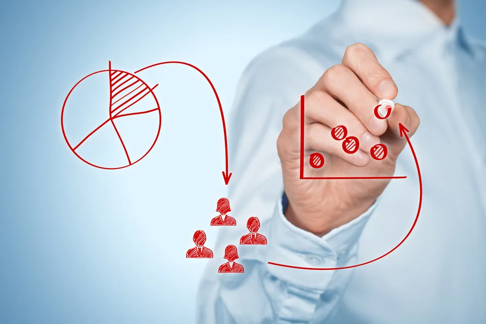 A man draws a chart, illustrating how competitive benchmarking helps visualize market performance.