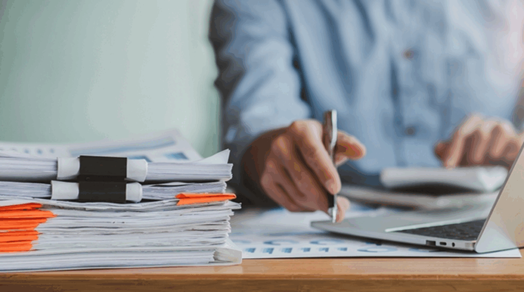 A person handles paperwork, navigating bureaucracy and focusing on important tasks to streamline the process.