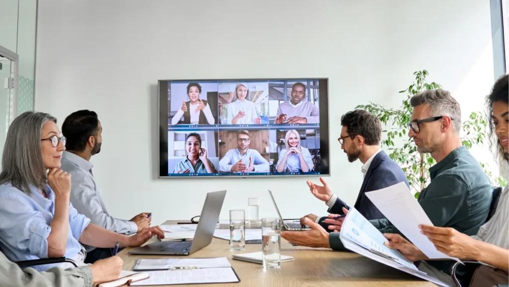 A hybrid team collaborates on job creation strategies using both virtual tools and in-person insights.