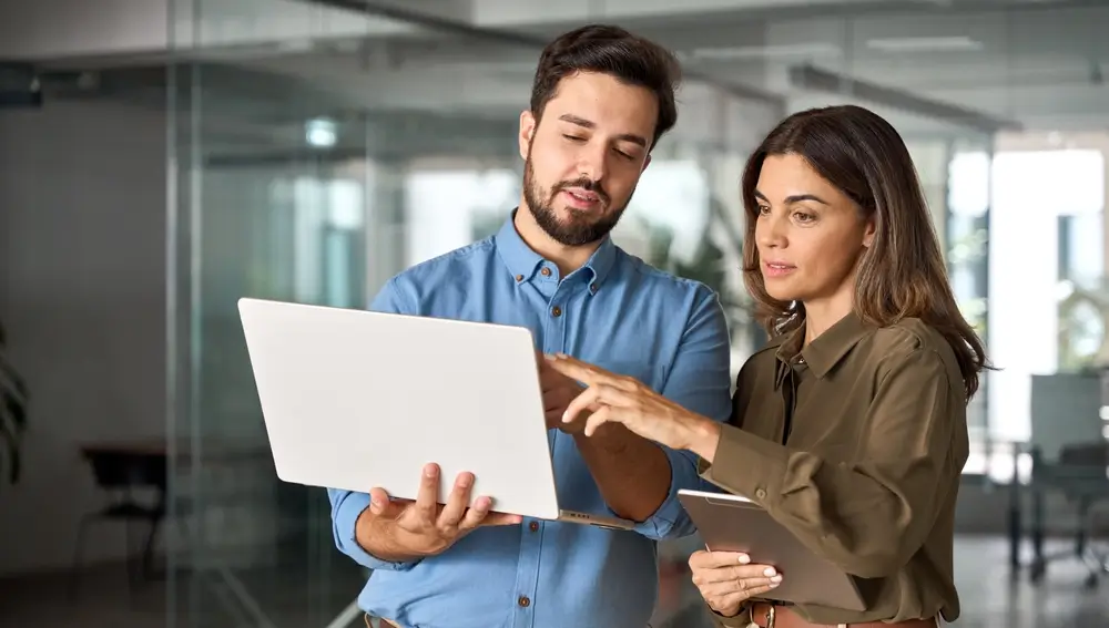 Two busy professional business people working in office with computer.