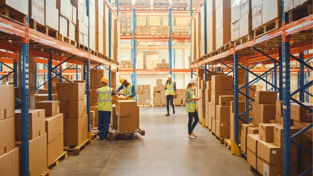 Warehouse staff organize boxes and track stock in a large facility, applying effective inventory management strategies.