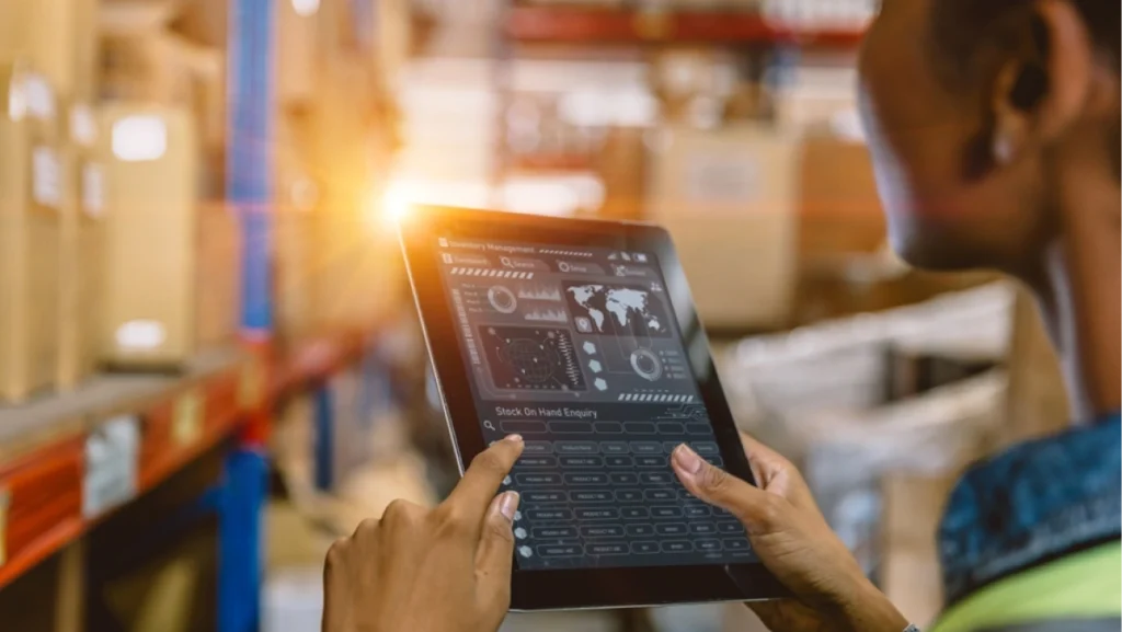 Tablet displays real-time inventory data in a warehouse setting, showcasing effective inventory management strategies.