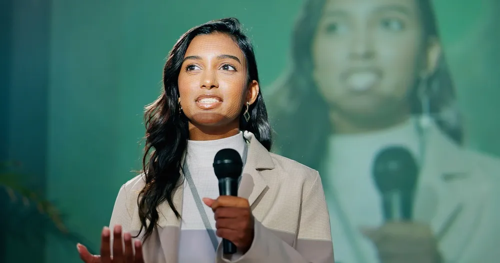 Conference, presentation or seminar and public speaking woman with microphone on stage for development speech