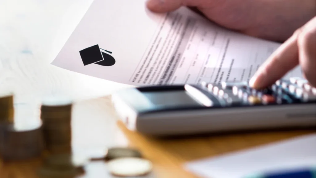 Man counting college savings fund, tuition fee or student loan with calculator. Education price and expenses concept. Money and papers on table. Calculating budget and planning finance.
