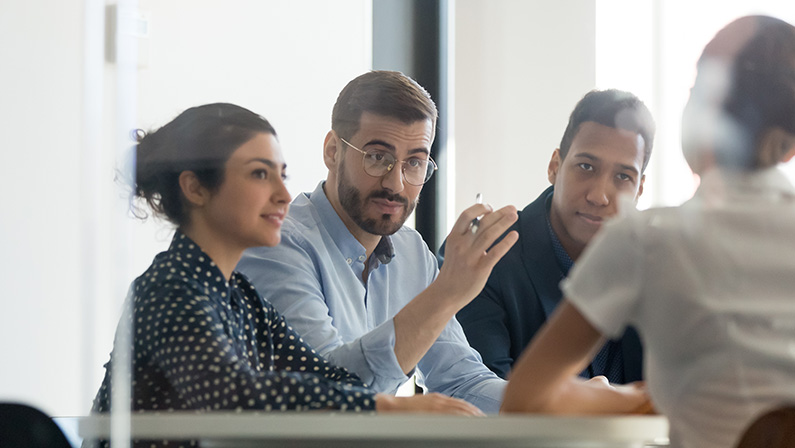 A diverse team in a meeting discusses strategies to overcome labor shortages and maintain business productivity.