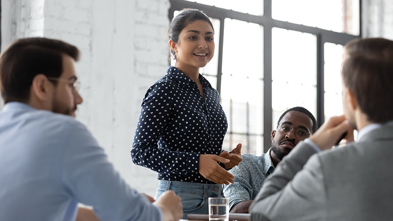 Inspired speaker. Confident indian businesswoman convincing thoughtful multiethnic business partners on negotiations young multiracial female responsible executive making report on corporate briefing
