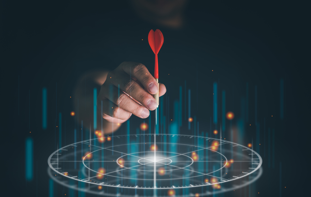 Businessman holding dart above digital target to symbolize precise decision-making with competitive intelligence.